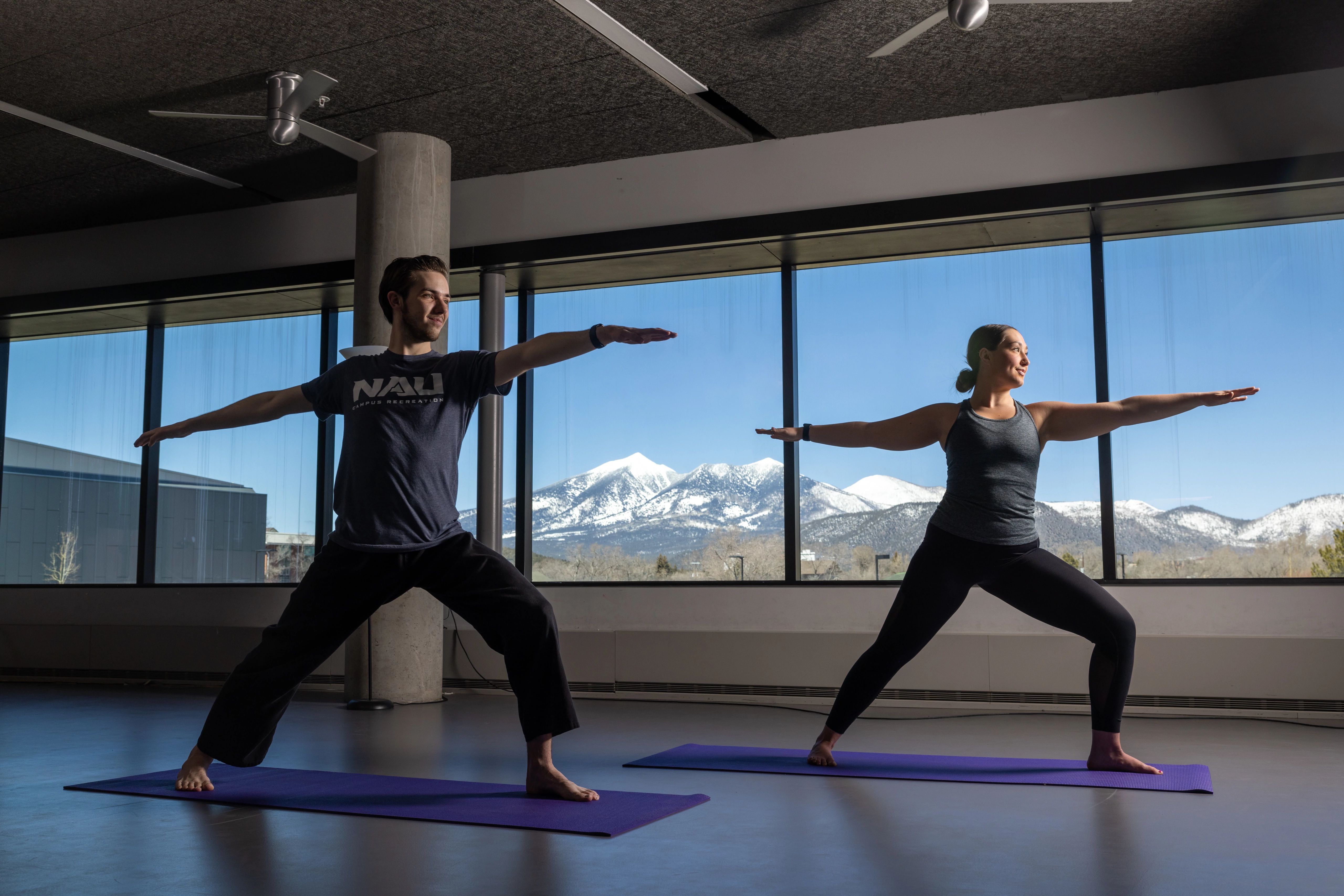 Two students holding a yoga pose.
