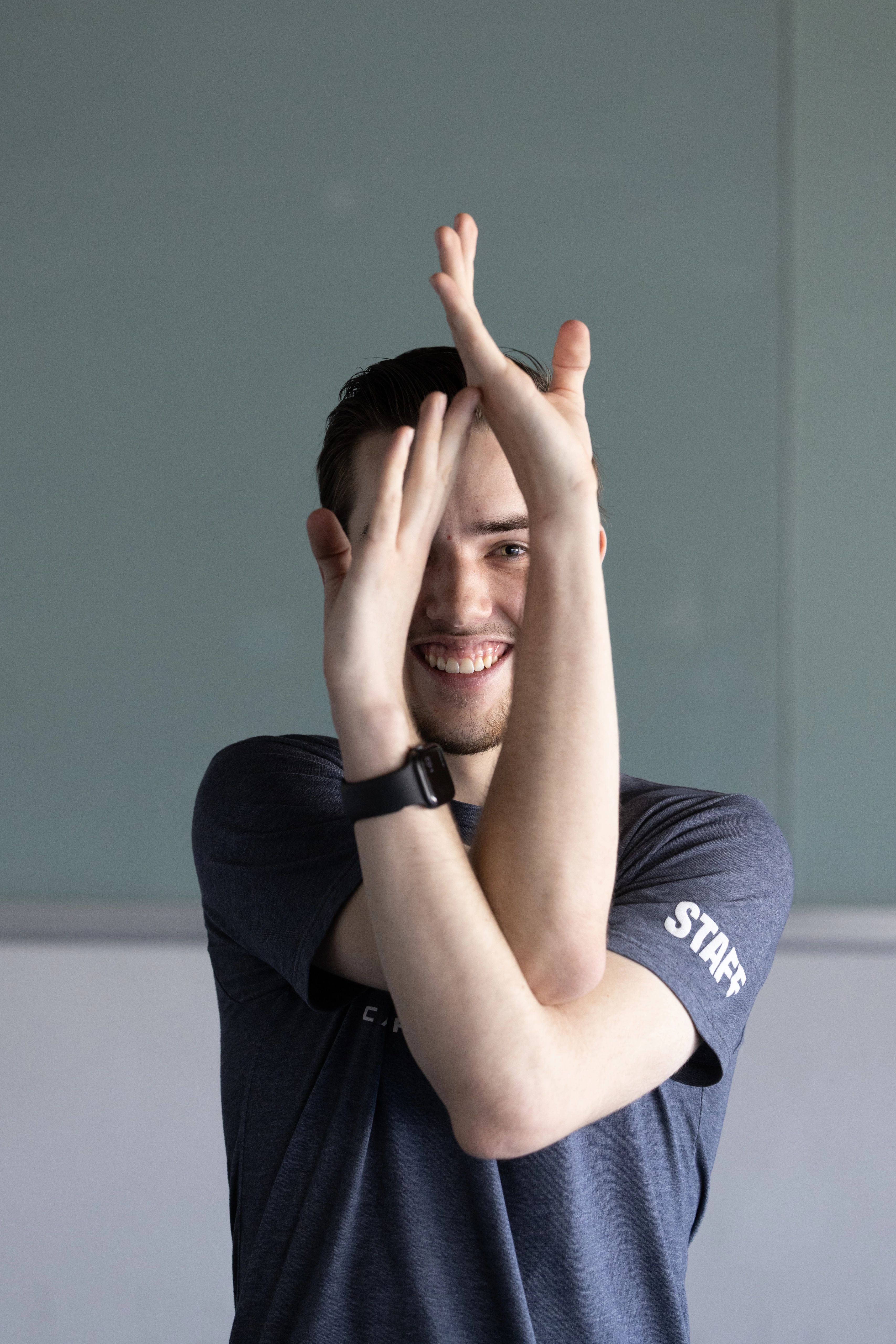 Yoga instructor holding his hands up in a intertwined pose.