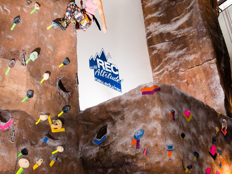 Student climbing up Campus Recreation Fitness Climbing Wall.