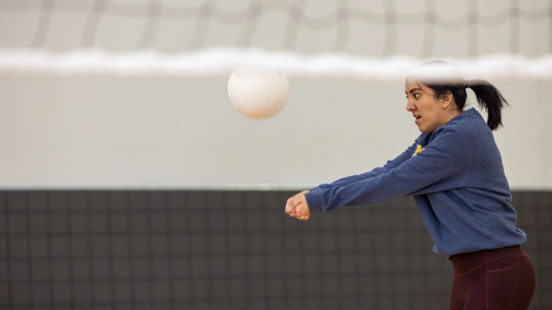 Female student hitting a volleyball.