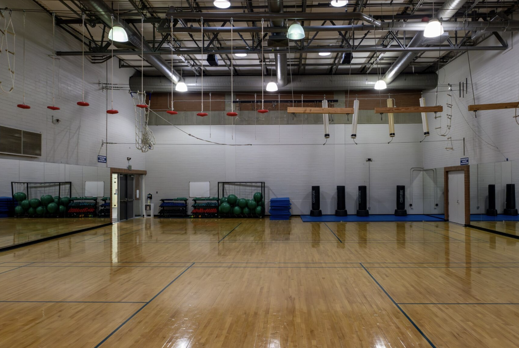 The inside of the gym with obstacle course hanging from the ceiling.