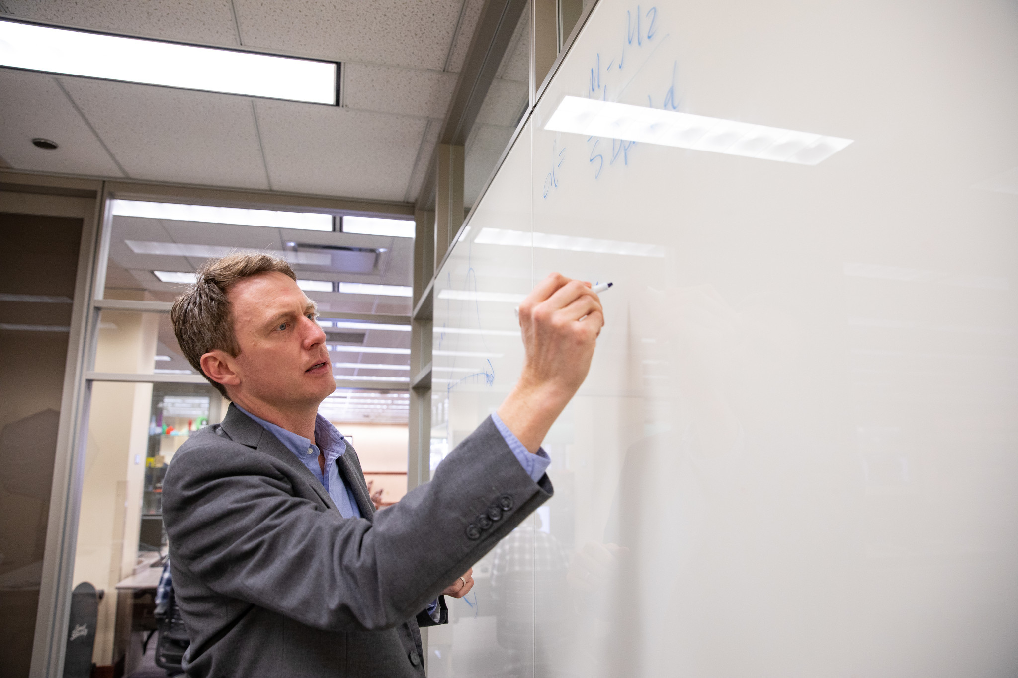 Faculty member writing on a white board