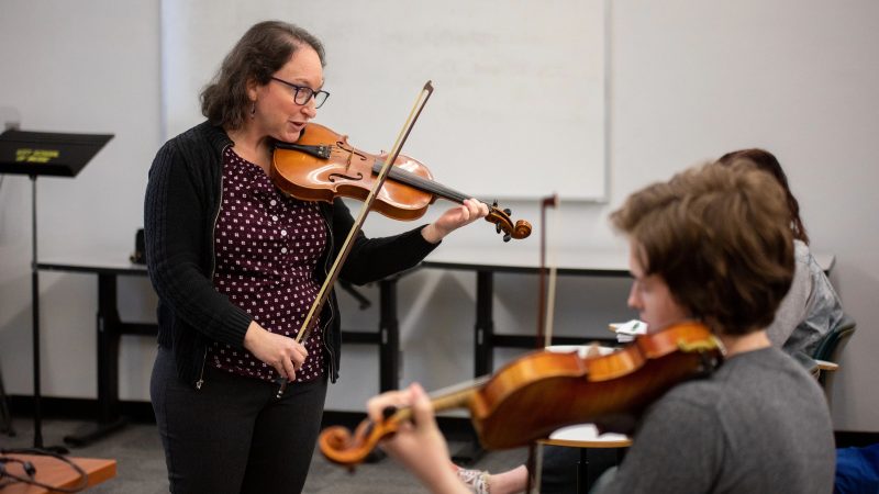 Faculty member playing the violin.