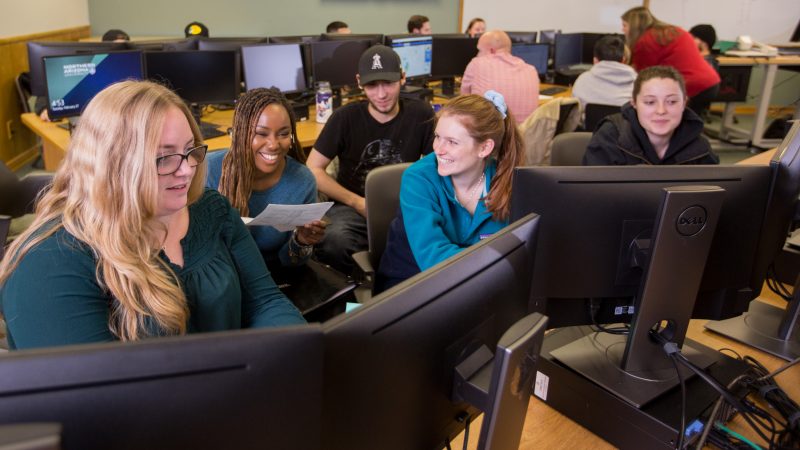 Students laughing and collaborating on a project in a CCJ classroom.