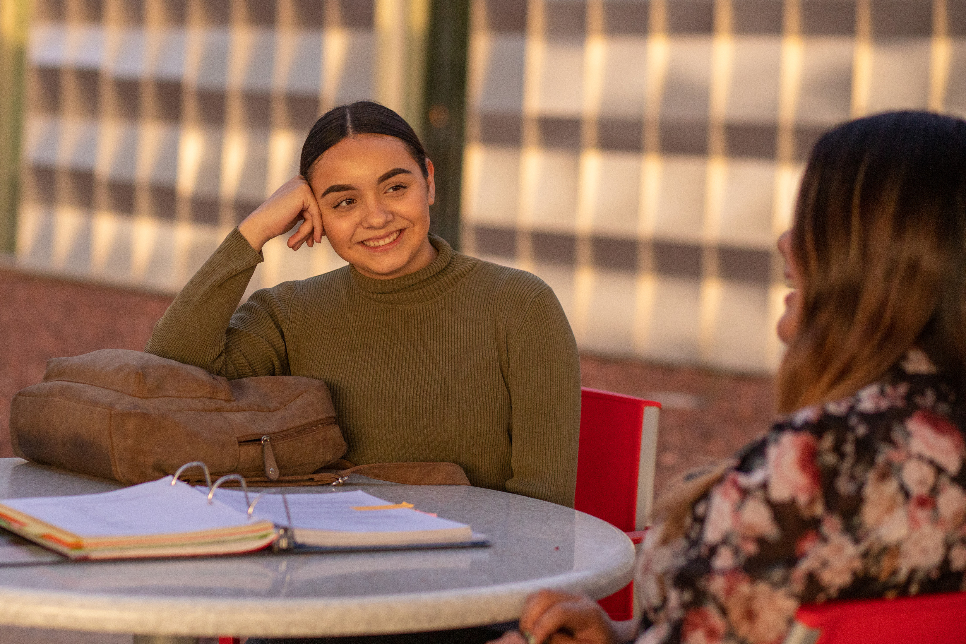 Two students sitting outside and talking.