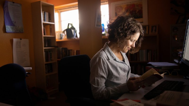 N A U's Gioia Woods reading at her desk.