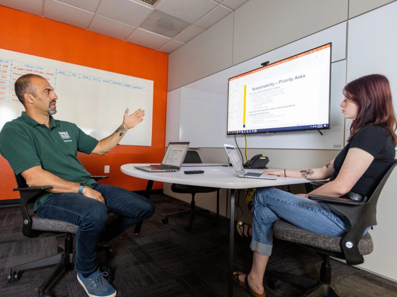 N A U's Abraham Henn discusses sustainability with a student.