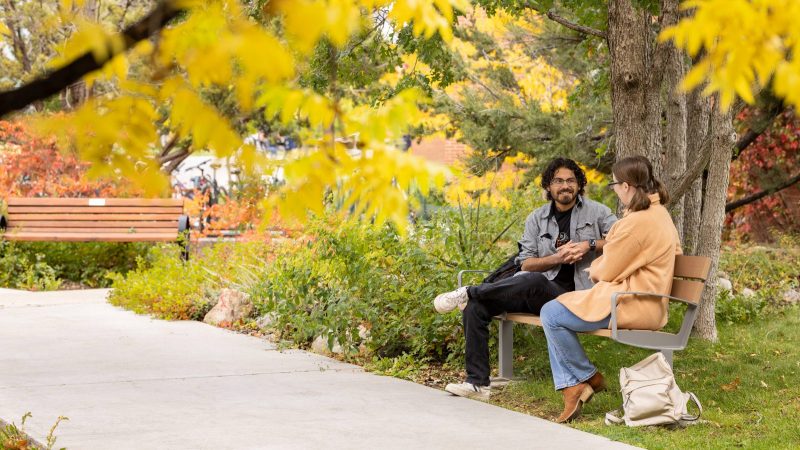 N A U students chat on a bench on campus.