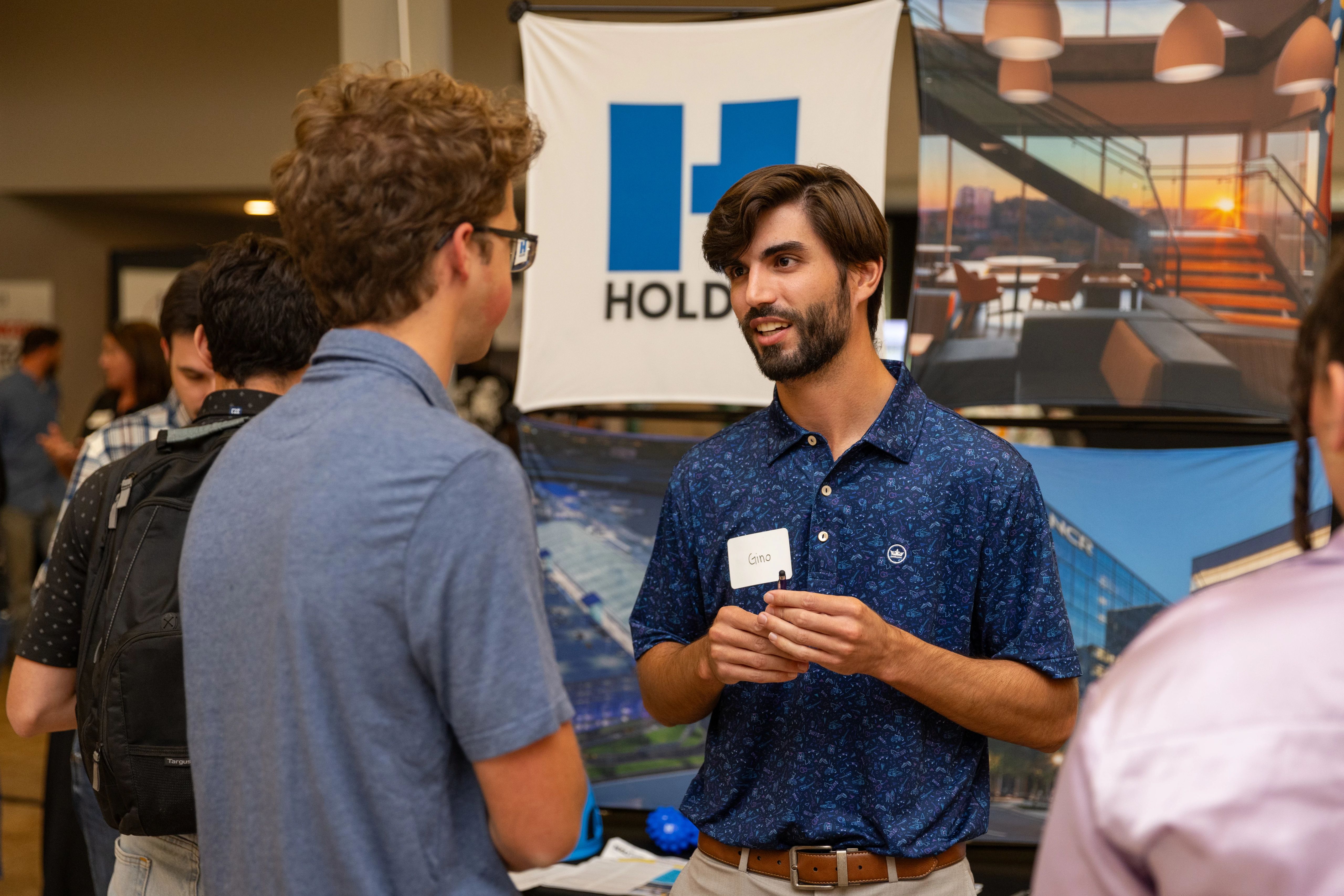 A presenter and student talking with each other at a career fair.