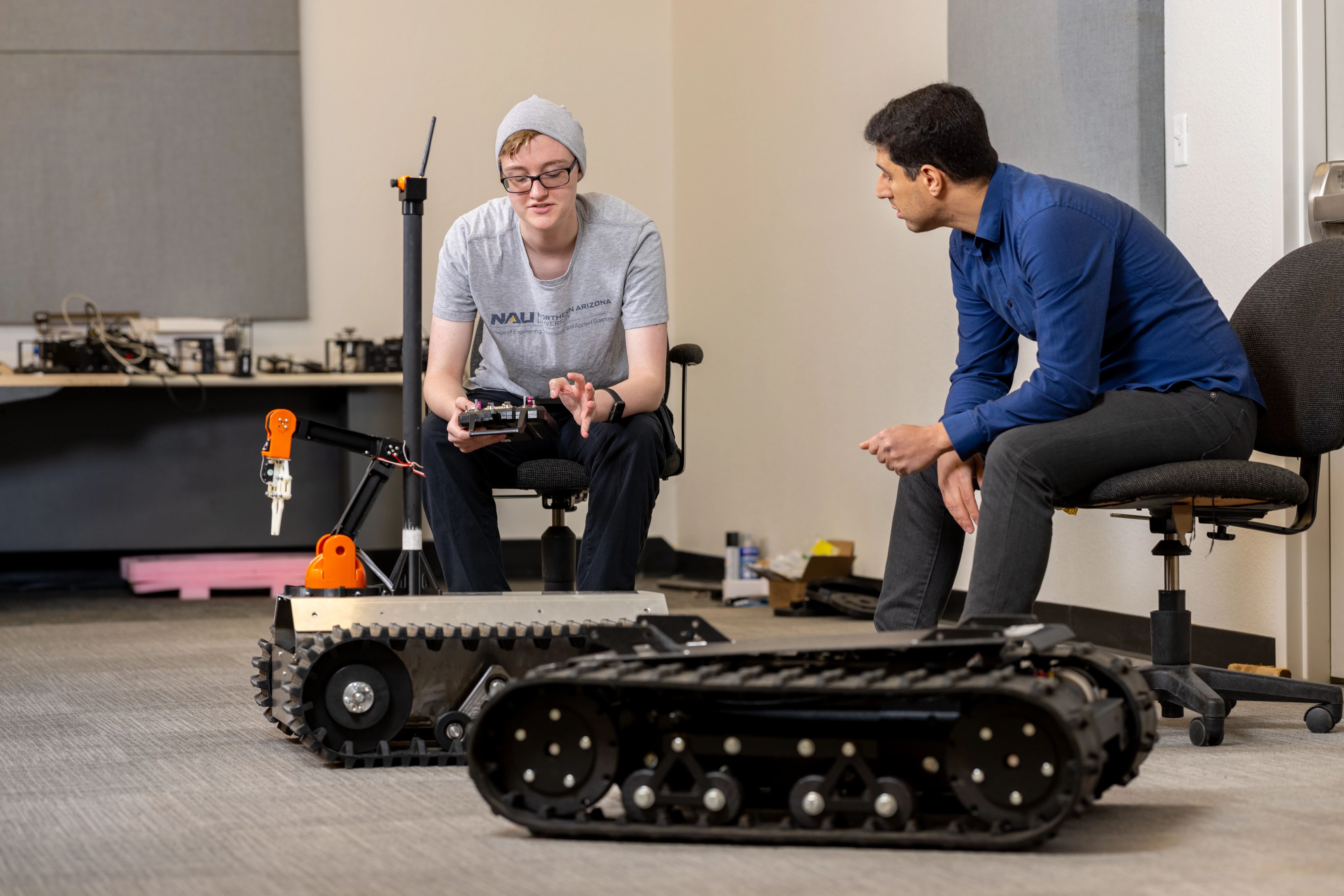 Student and professor examining remote-controlled machines.