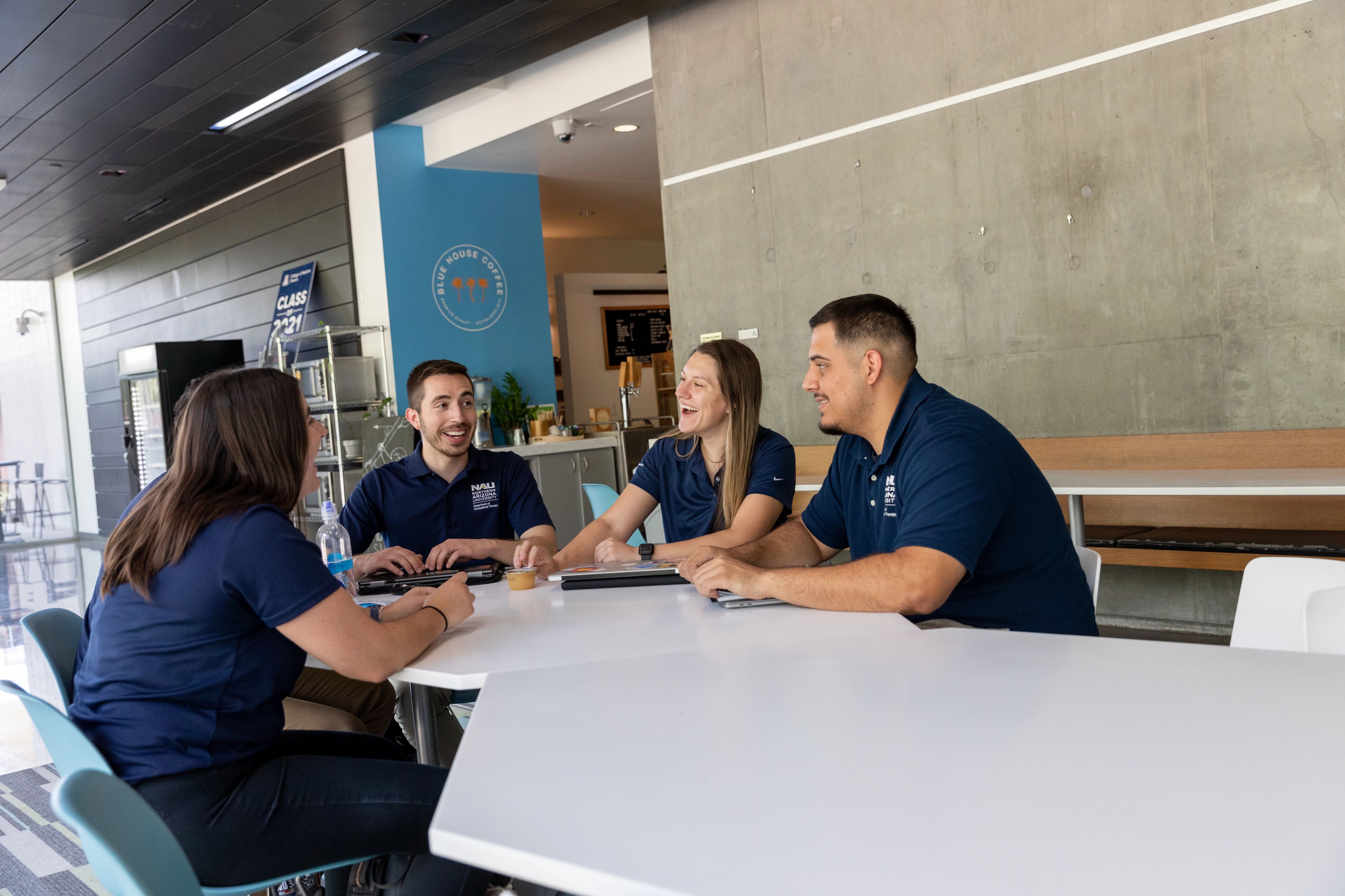 Group of four students chatting at a table at the Phoenix Biomedical campus.