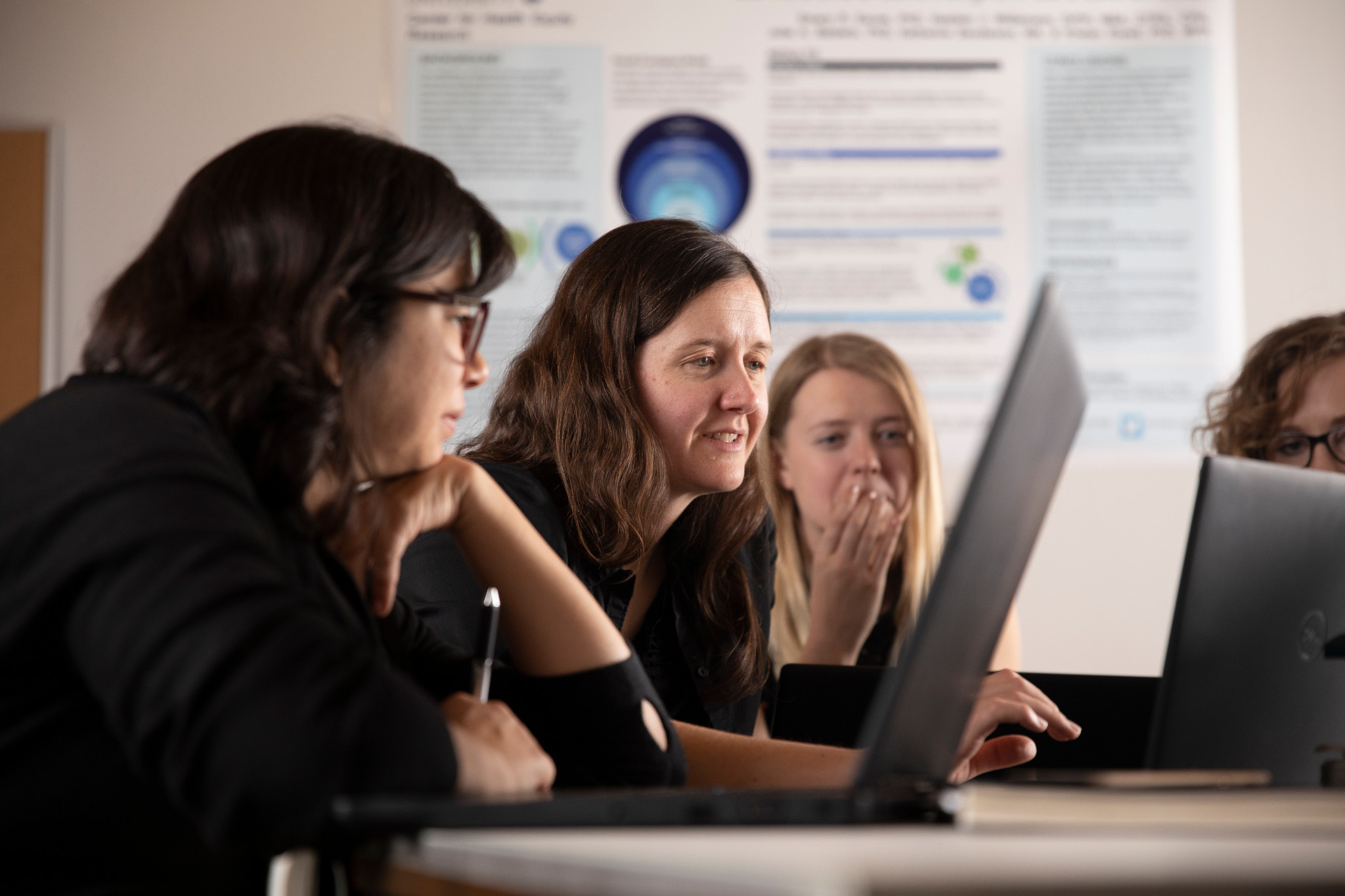 Emery Eaves and students working on a project on the computer.