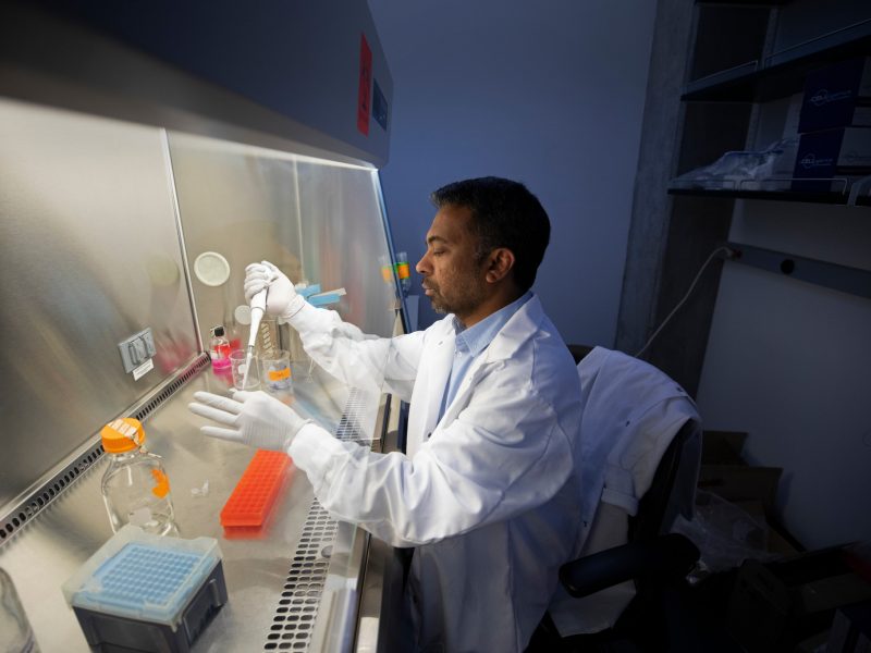 Researcher filling vials in his lab.