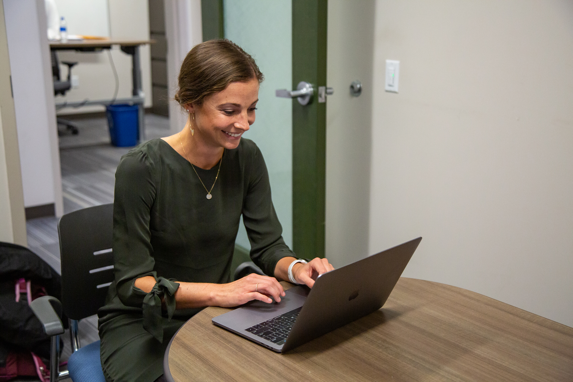 Female sitting at a table working on a laptop computer.