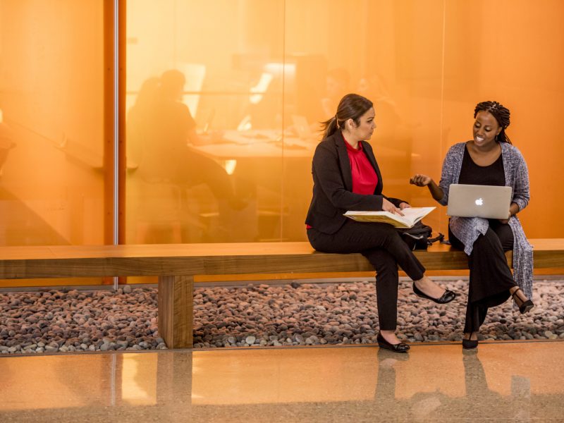 Two people sitting on a bench at the Arizona Biomedical Centre.