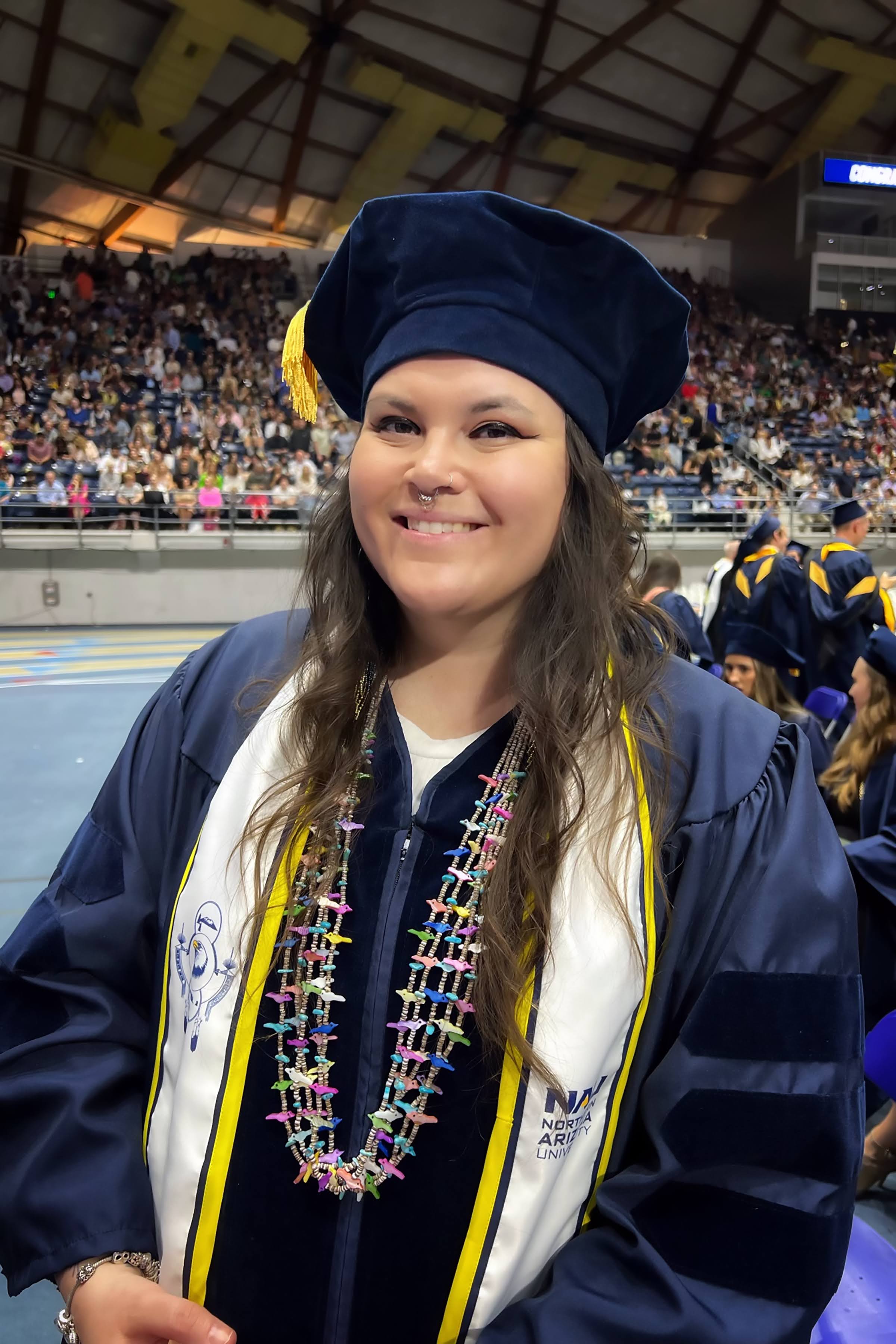 Carly Camplain in graduation and cap at NAU graduation.