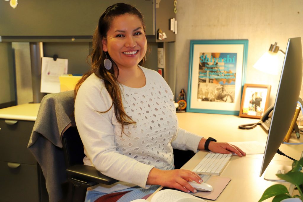 Carmenlita Chief smiling at computer desk.