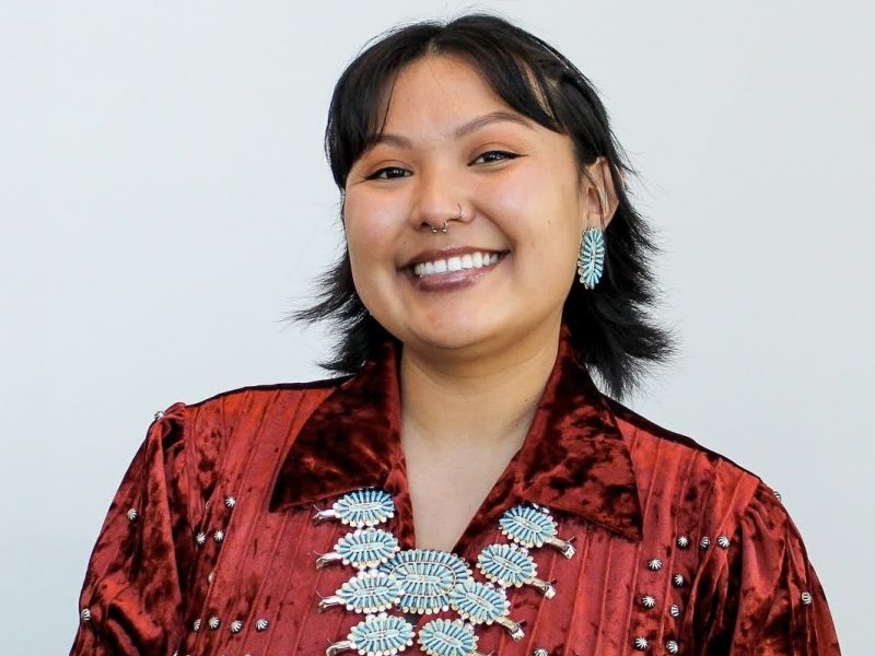 Chassity Begay wearing traditional red clothing and turquoise jewelry.