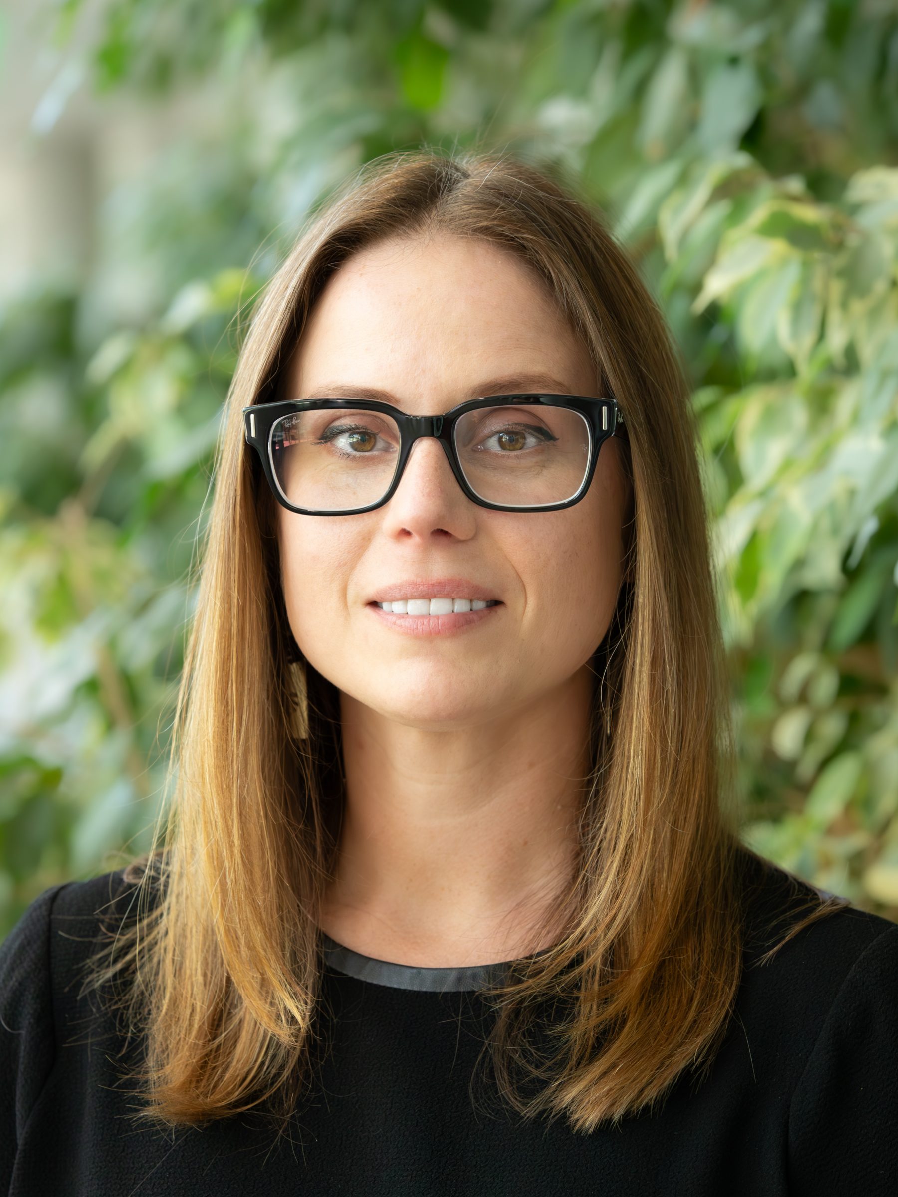 Christine Kirby iis wearing a black top and glasses.