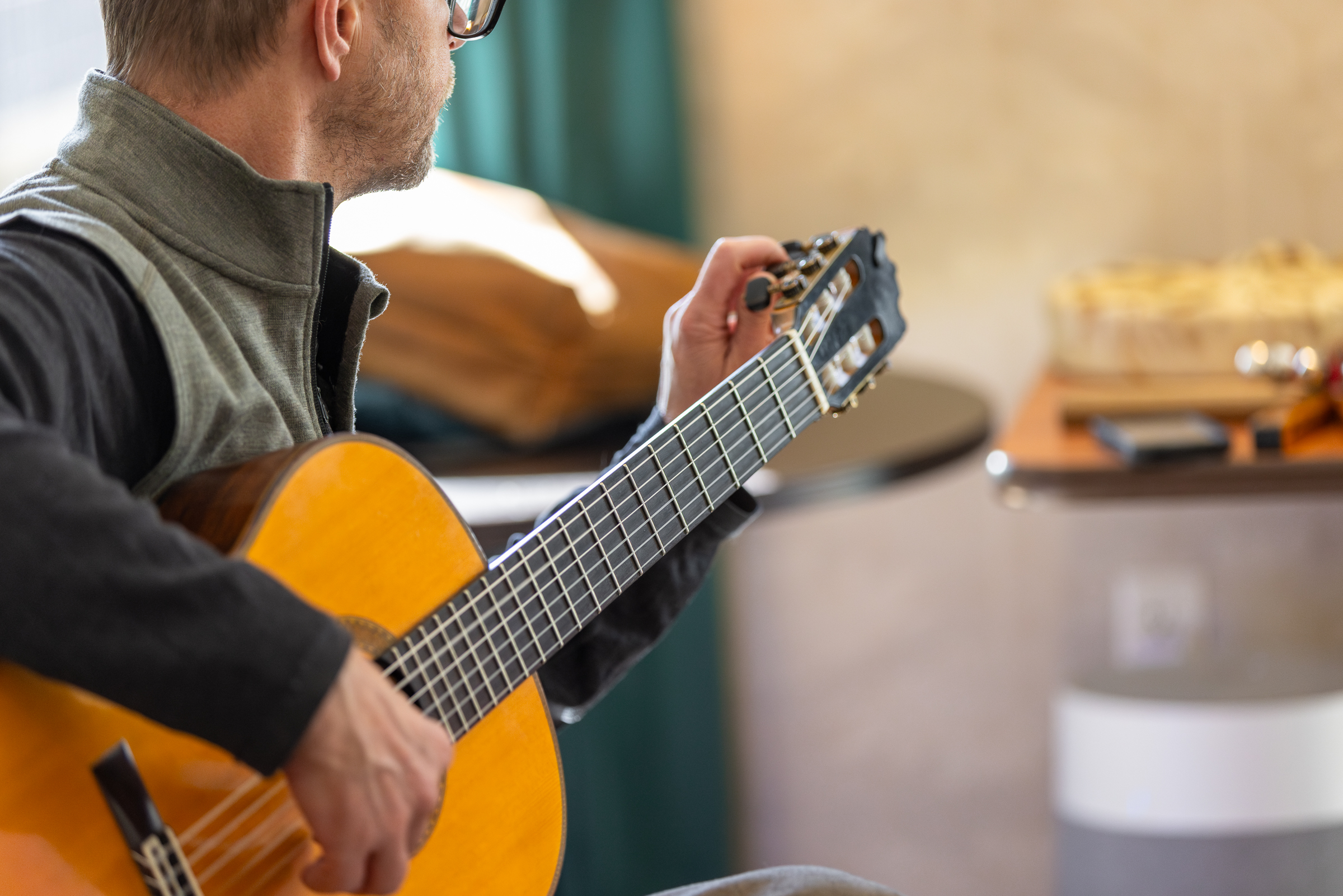 Craig Yarbrough tunes his acoustic guitar in preparation for the music session.