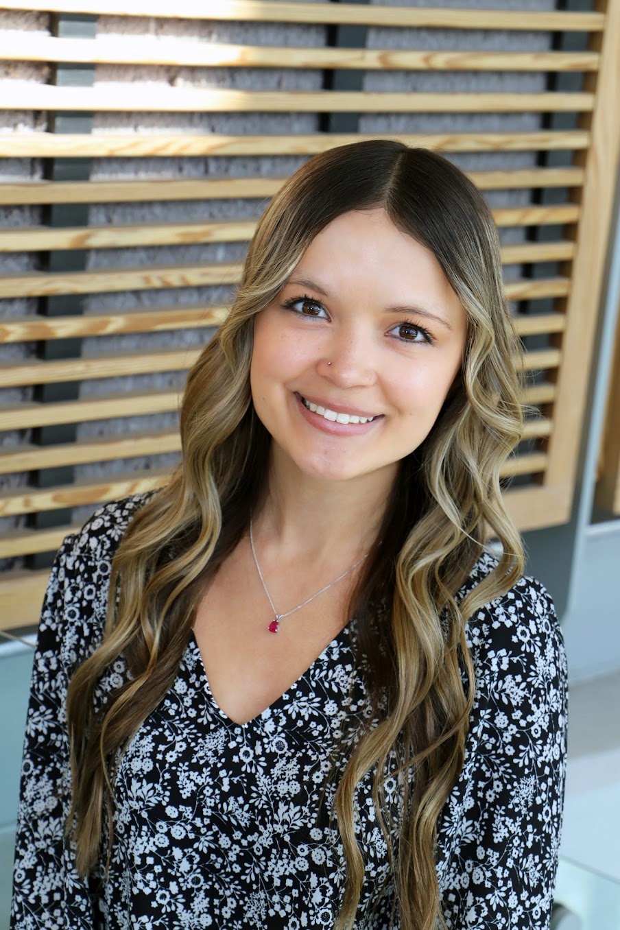 Hailey Clinton smiling wearing a blouse and necklace.