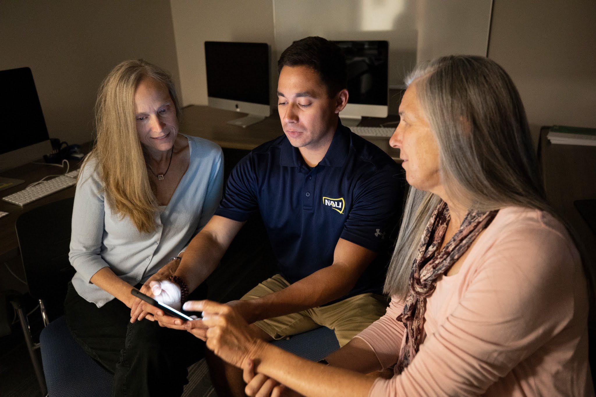 Two tag team members assist a NAU Researcher.