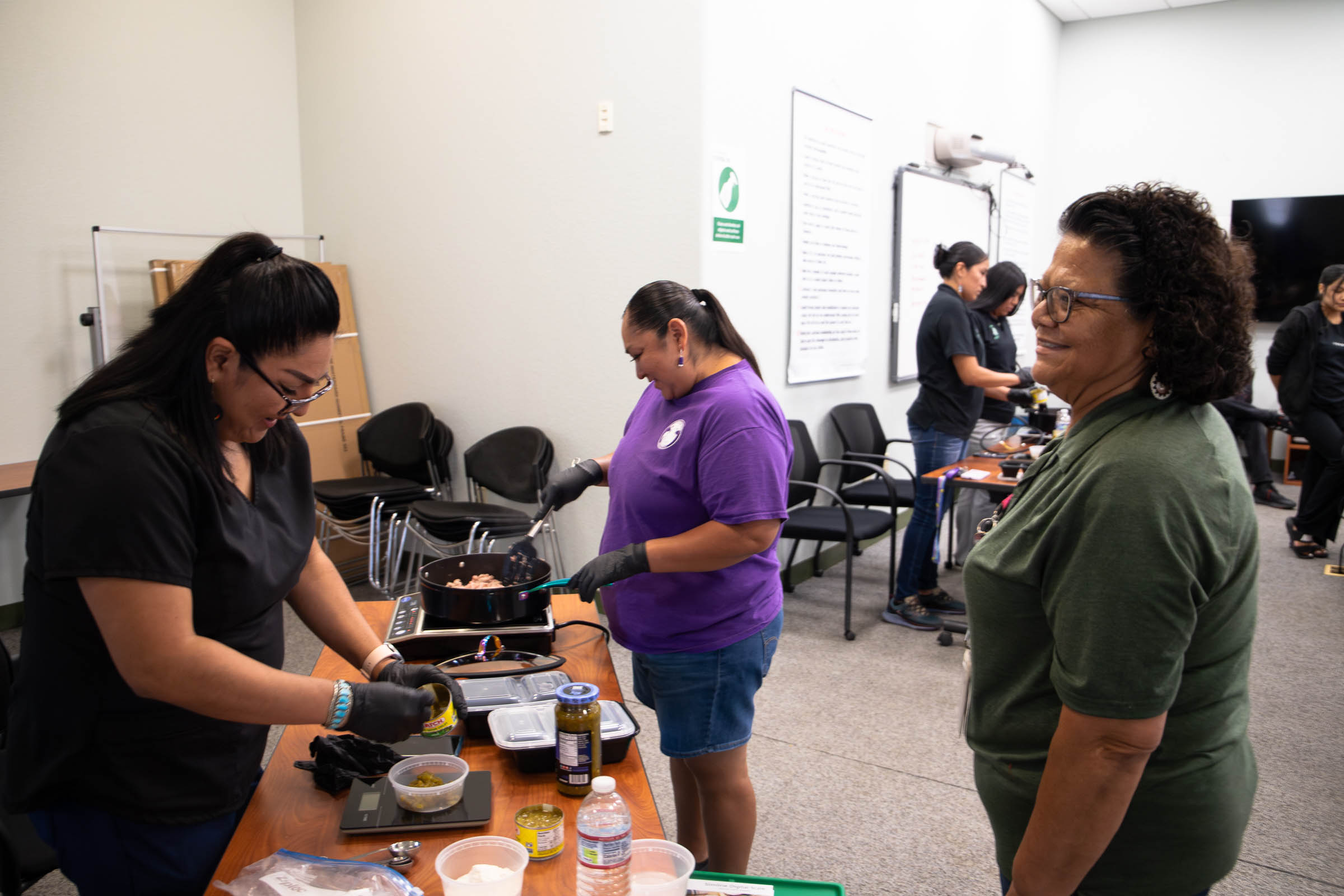 Rosemary Sullivan (right) waits in line for a plate of delicious food prepared by HSDPI staff for the community.