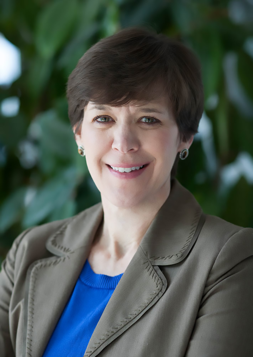 Julie Baldwin wearing a blue shirt and brown blazer.