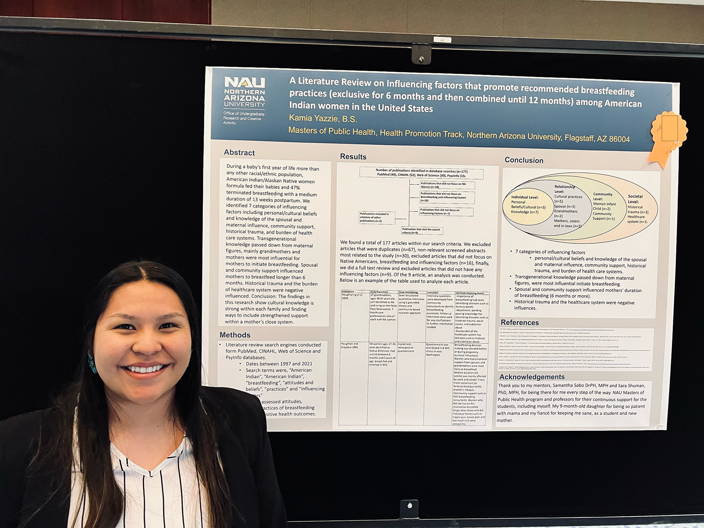 Kamia Yazzia smiles next to her poster presentation.