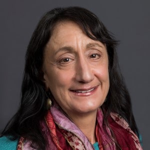 Karen Pugliesi, PhD portrait wearing a teal top with a burgundy scarf.