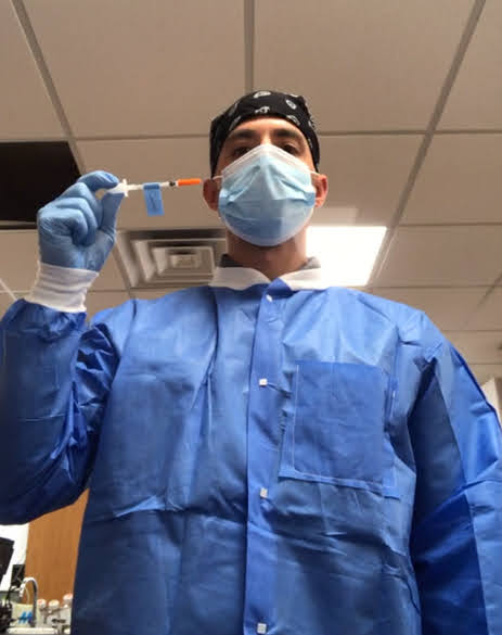 Mike Anastario wearing personal protective equipment while flushing used syringes.