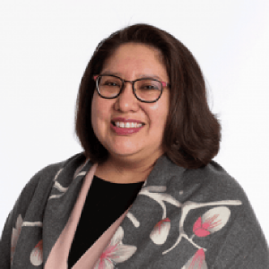 Myra Parker, JD, MPH, PhD portrait wearing a black shirt with a grey, pink, and white floral jacket.