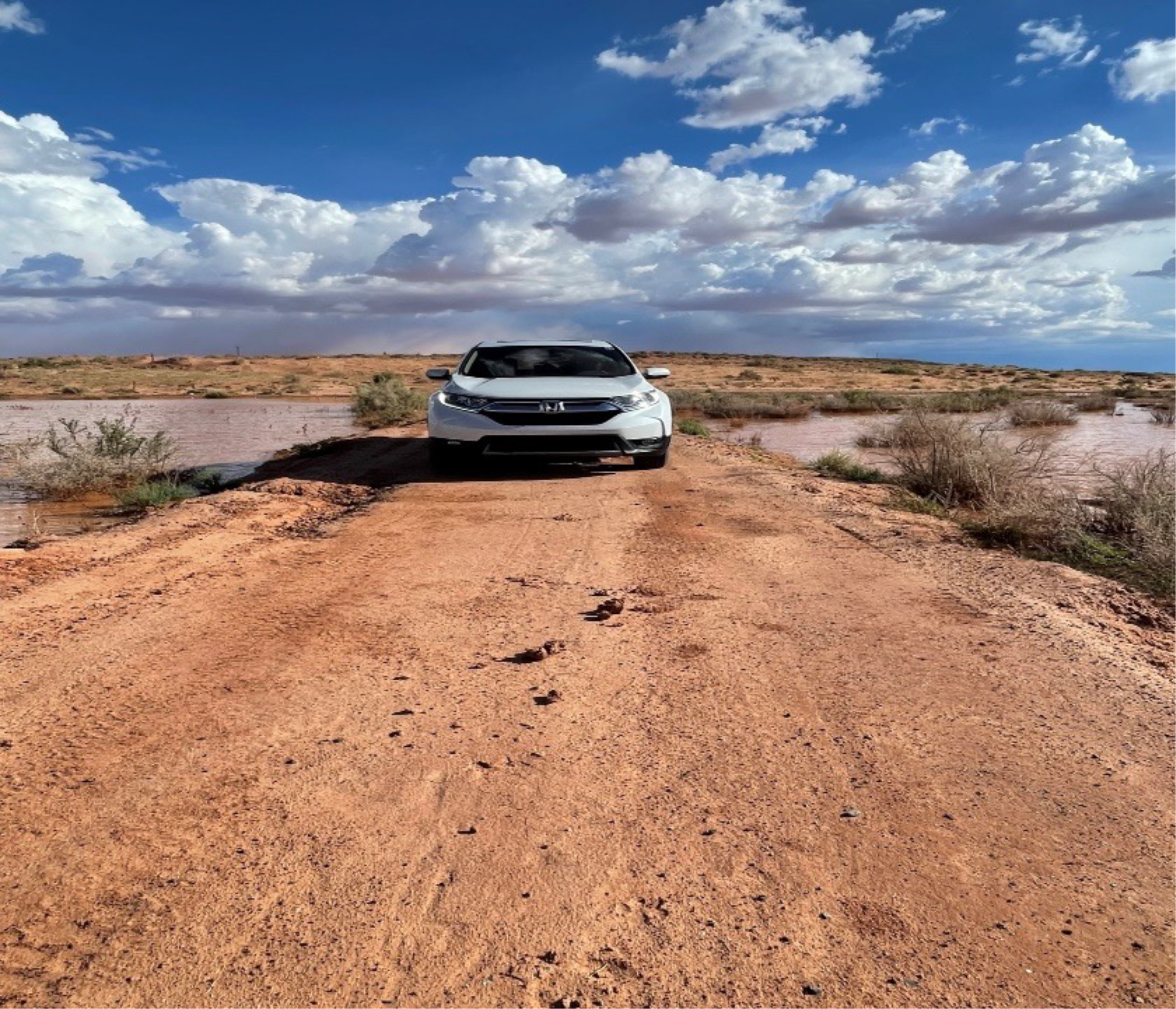 N A U car drives down a muddy road. 