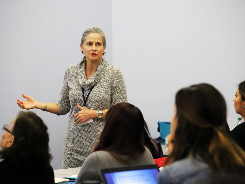 Nicolette-Teufel-Shone in front of a classroom teaching students.