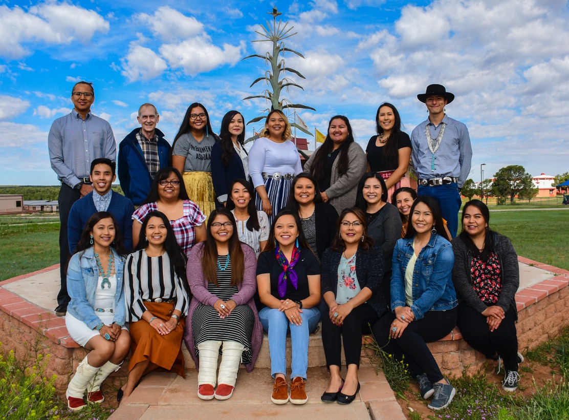 SREP Students sit together outside in a group posing for a picture.