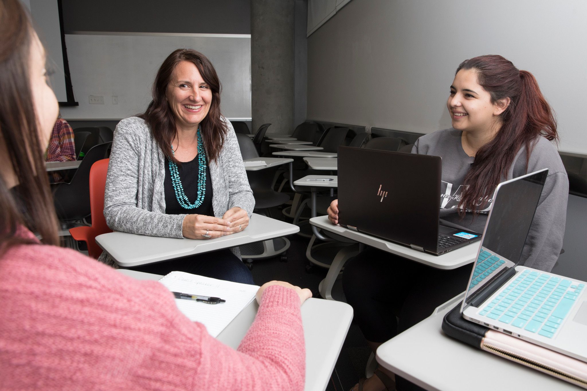 Faculty and graduate students sitting around a table smiling.