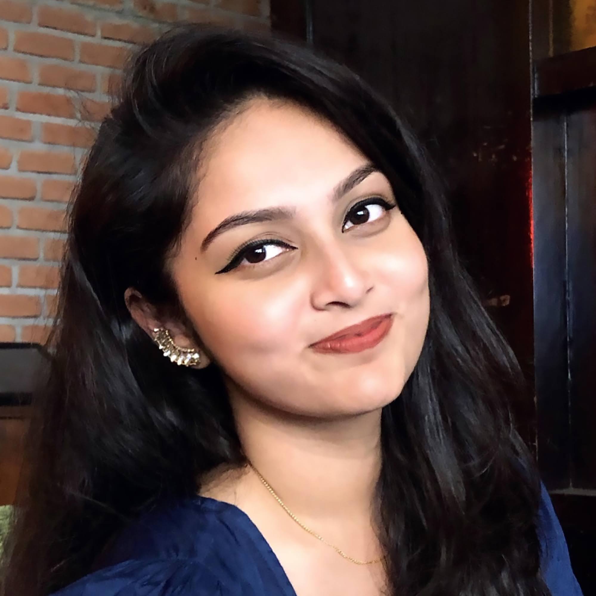 Shreya Raju portrait with brick wall background.