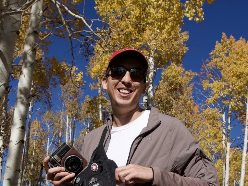 Sklyer Bordeaux wearing sunglasses in front of yellow aspen trees.