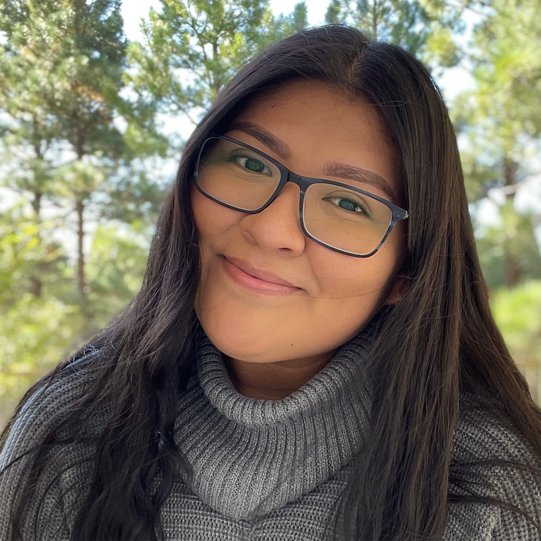 Tressica Johnson portrait smiling and wearing a grey sweater.