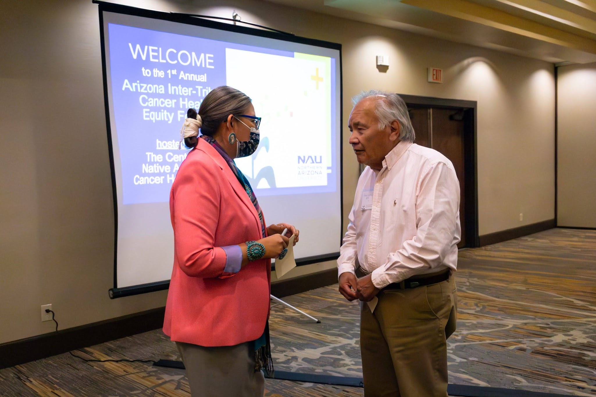 Two AICHEF participants gather to speak to each other on the topics they heard.