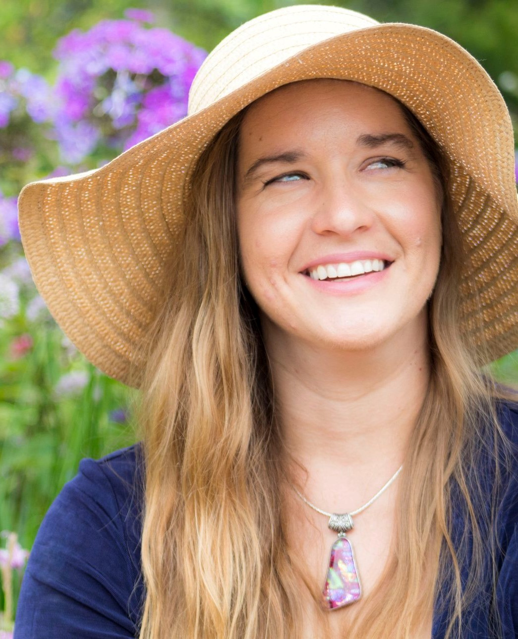 Valerie Seeton wears a sunhat outside as she smiles and looks up.