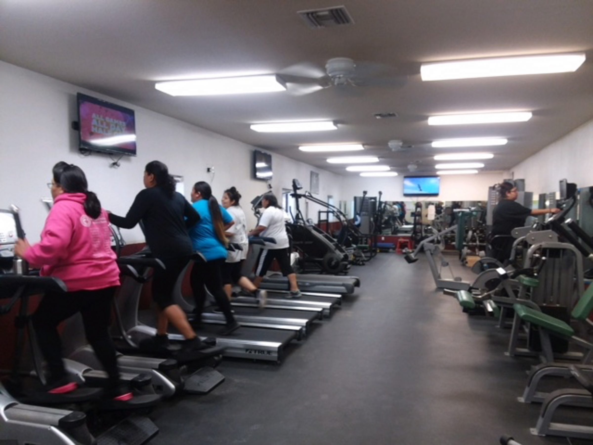 People using treadmills in fitness room.