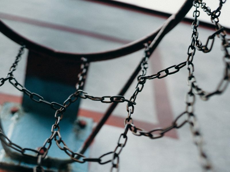 View from within a basketball hoop net looking out at gym.