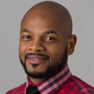 Jarrett Johnson, DrPH, MS, CHES portrait wearing a checkered red shirt with a black tie.