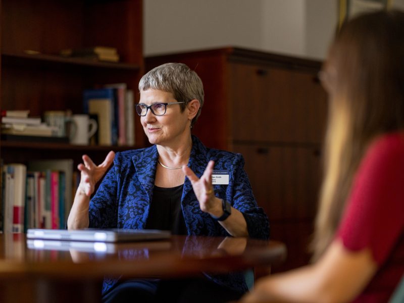 Lillian Smith, dean of CHHS, sitting in a chair in her office talking to guests.