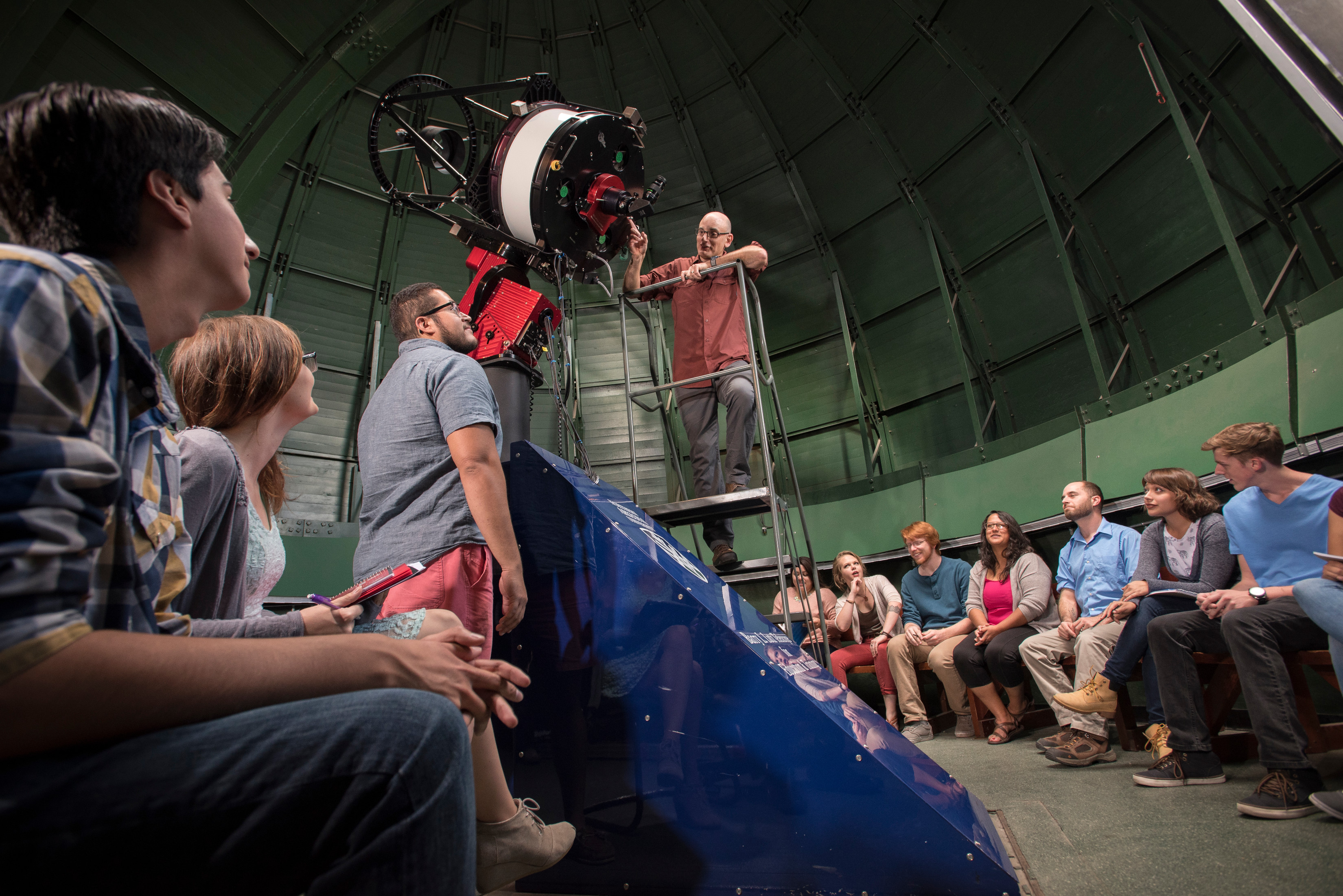 Astronomy students looking at a telescope.