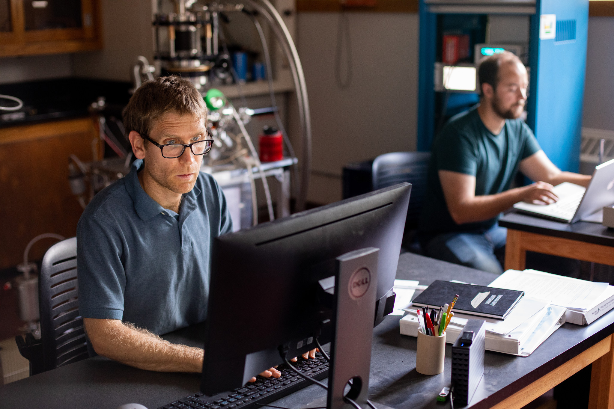 Professor mark loeffler and a colleague working on their computers.