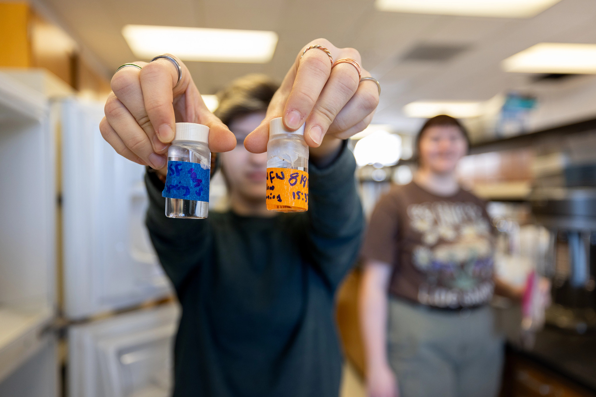 Student holding up soil testing samples in the forestry soil laboratory.