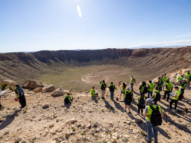 Group of students on a field trip to a meteor crater.