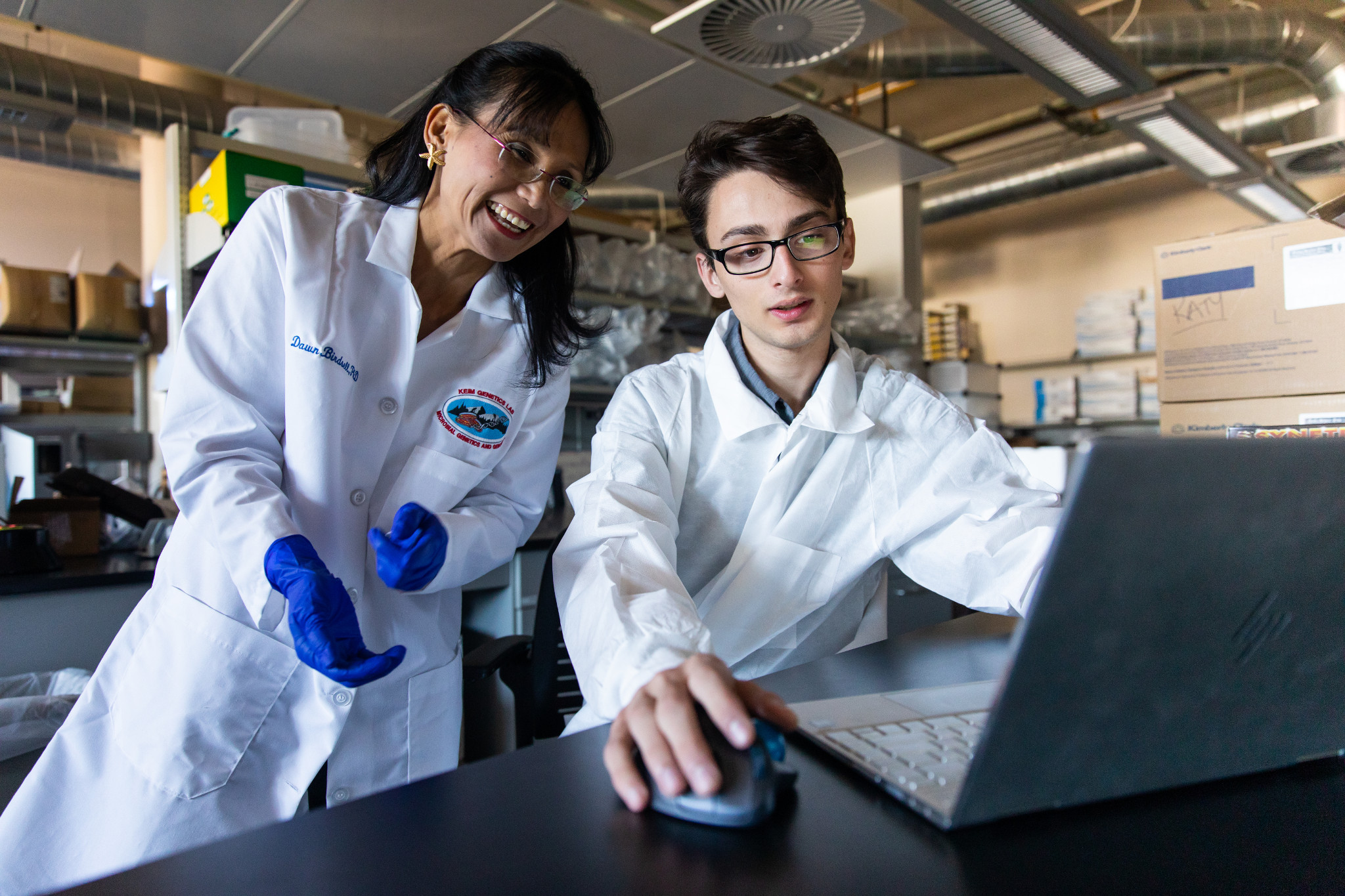 Two lab students looking at a laptop.